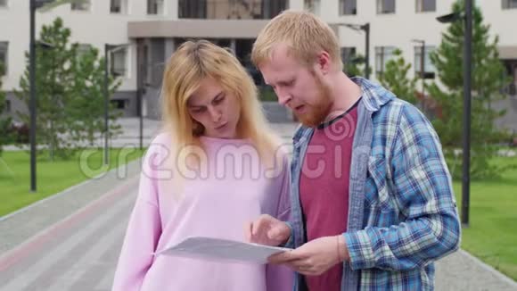 男人和女人靠在重要的文件上学生学习作业年轻人站在视频的预览图