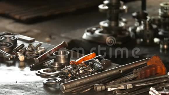 金属桌子上摆着汽车修理工的工具和备件视频的预览图
