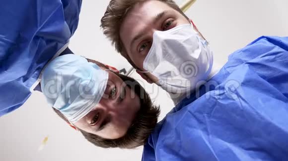 两名外科医生在手术成功后正在检查一名病人并握手视频的预览图