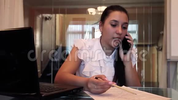 漂亮的年轻商务女孩坐在办公室里用手机讨论一个商务项目视频的预览图