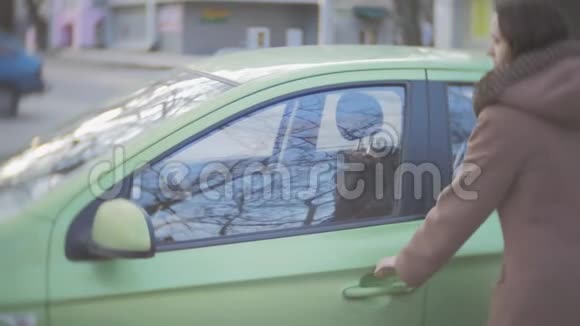 一个中年妇女坐在绿油油的车里视频的预览图