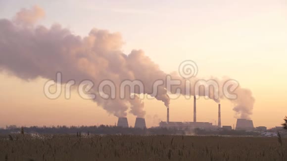 工厂在日落时从管道中排放烟雾污染物进入大气视频的预览图