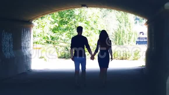 一对夫妇穿过隧道拥抱亲吻的剪影视频的预览图