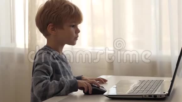 那个男孩坐在靠窗的笔记本电脑旁视频的预览图