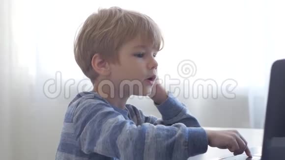 那个男孩坐在靠窗的笔记本电脑旁视频的预览图