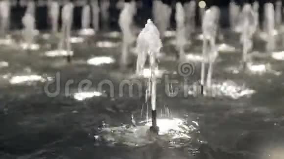 在一个令人惊叹的喷泉中流动着清澈的水流在夜间有闪光特写视频的预览图