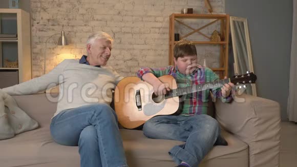 孙子为爷爷弹吉他音乐一位老人和一位年轻的胖子坐在一起弹吉他视频的预览图