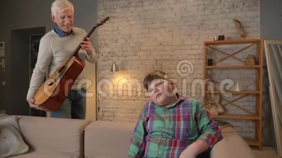 爷爷送给孙子一把吉他一份礼物一份惊喜一个老人把吉他给一个年轻的胖孩子家庭视频的预览图