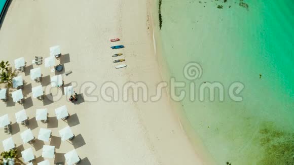 白色海滩上的海滩雨伞和甲板椅视频的预览图