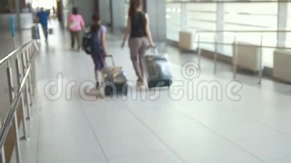 带着手提箱前往国际机场的家庭旅客的后景视频的预览图