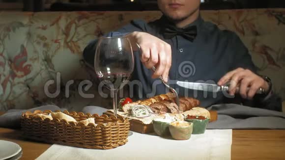 在餐馆午餐或晚餐时间吃饭喝酒的英俊男子女子视频的预览图
