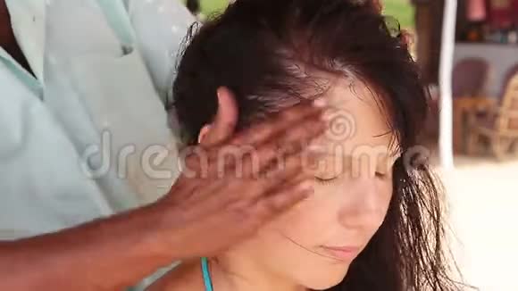 治疗师她的手对女人做头部按摩视频的预览图