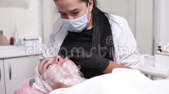 4k拍摄专业的面膜医生在中胚层治疗中对女性脸颊进行多次注射视频的预览图