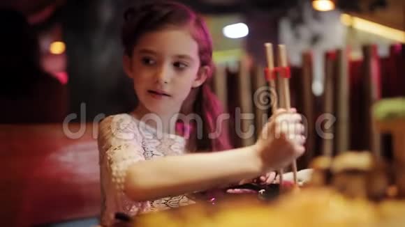 快乐的女孩在日本餐馆用筷子吃春卷视频的预览图