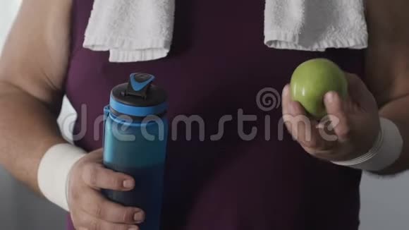 超重男性在训练后喝静水吃青苹果饮食视频的预览图