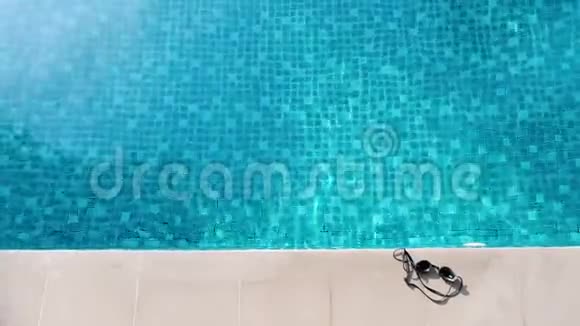 夏季的游泳池蓝色的水和眼罩以及酒店内白色的酒吧地板砖供您在度假日放松和放松视频的预览图