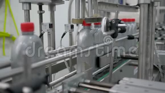 生产机器将塑料瓶的红色盖子固定在电机油厂的传送带上视频的预览图