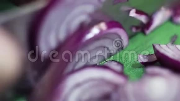 洋葱正在绿色餐桌上用锋利的刀切成戒指视频的预览图