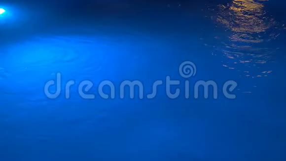 喷泉中闪烁着水下灯光在水下的蓝色和黄色的灯美丽的夜晚波浪般的光照视频的预览图