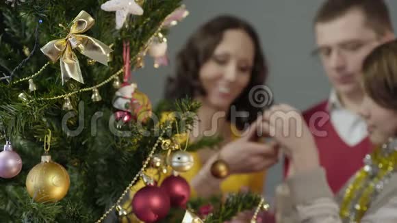 爱的父母帮助他们的女儿装饰圣诞树神奇的时刻视频的预览图