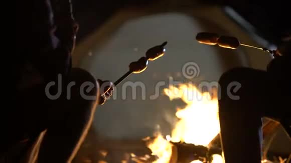 在篝火上烤香肠在树林里野餐远足和休息视频的预览图