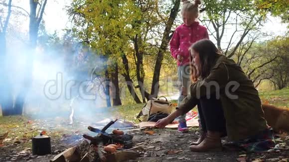 在秋天的森林里微笑着姐妹野餐视频的预览图
