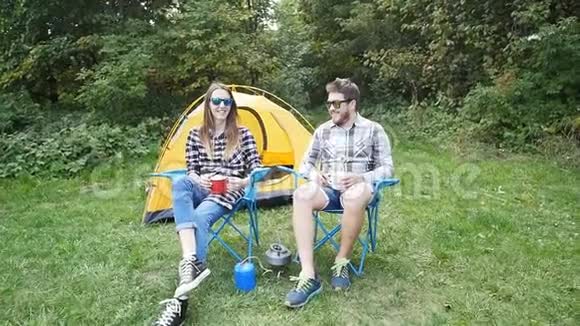 夏天在自然森林露营帐篷附近快乐的年轻夫妇视频的预览图
