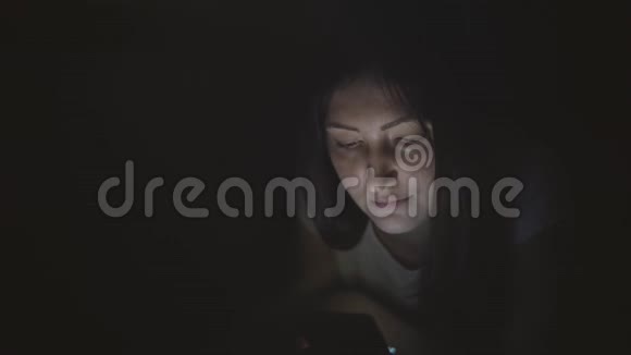 夜深人静的漂亮女人在社交网络里坐着一部手机视频的预览图