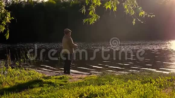 钓竿湖钓鱼男子夏季钓鱼吸引日落水户外日出鱼群镜头视频的预览图