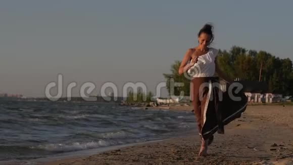 女人在日落和大海的背景下在海滩上奔跑享受大自然视频的预览图