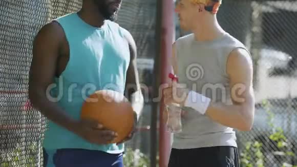 两个朋友握手在体育场讨论篮球比赛策略视频的预览图