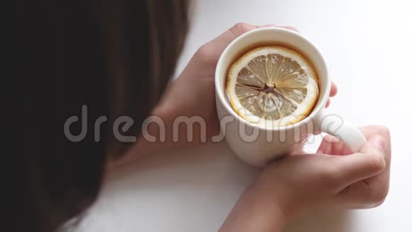 女孩手里拿着一杯金茶手里拿着一片香柠檬视频的预览图