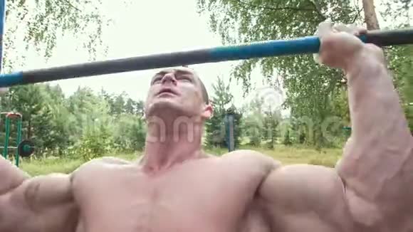 肌肉男在森林里用沉重的横杆摆动视频的预览图