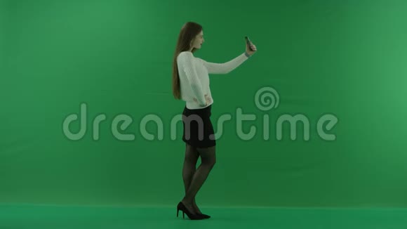 女孩站在她的右边在绿色屏幕上自拍视频的预览图