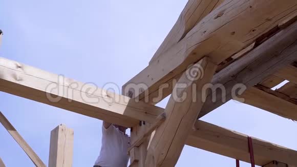 工人搭建和堆放木板木屋剪辑工人在房屋建筑工地安装漂亮的木梁视频的预览图