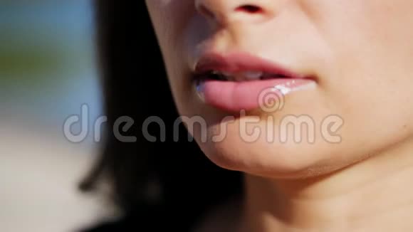特写美女迷人嘴唇的肖像她在嘴唇上涂上透明的唇彩并借助视频的预览图