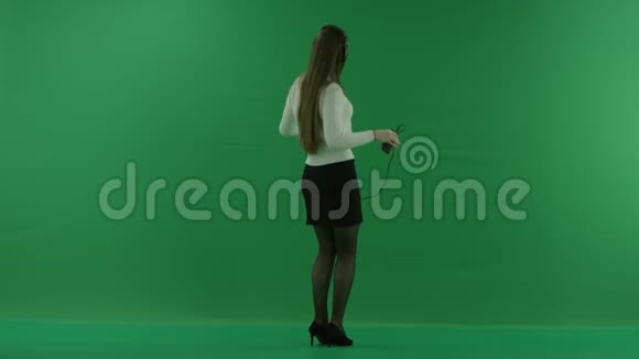 女孩正背对着镜头站着半转半转看着右边戴着绿色的耳机跳舞视频的预览图