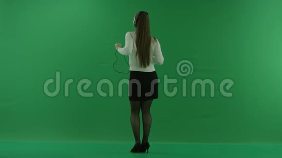 女孩正背对着镜头站着半转半转看着左边戴着绿色的耳机跳舞视频的预览图