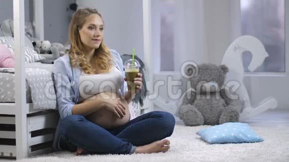 怀孕的女性带着绿色的冰沙微笑视频的预览图