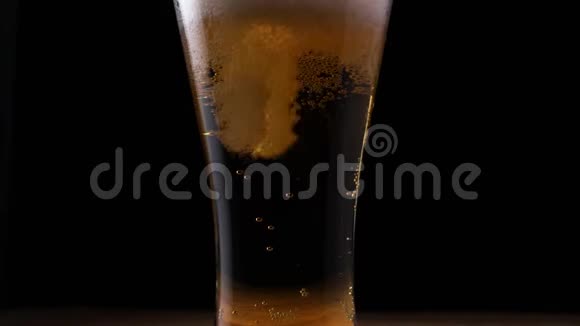 特写宏观啤酒泡沫上升时在黑色背景上加满视频的预览图