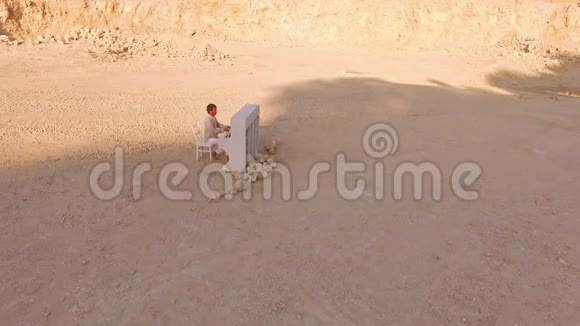 一个光着脚穿白衣的人在黄山间弹钢琴一只蝴蝶飞过他的头顶视频的预览图