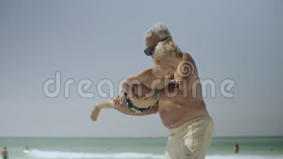 爷爷和他的孙子在海滩上玩得很开心视频的预览图