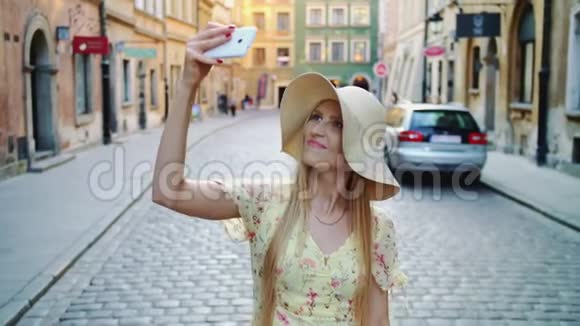 女人在广场自拍迷人的女人摆出自拍和站在城市广场视频的预览图