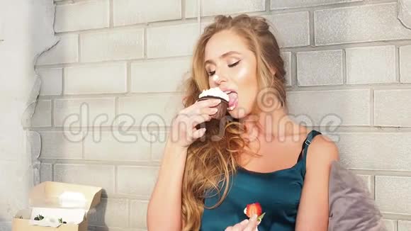 一个年轻漂亮的女人在卧室里吃早餐她用奶油吃蛋糕视频的预览图