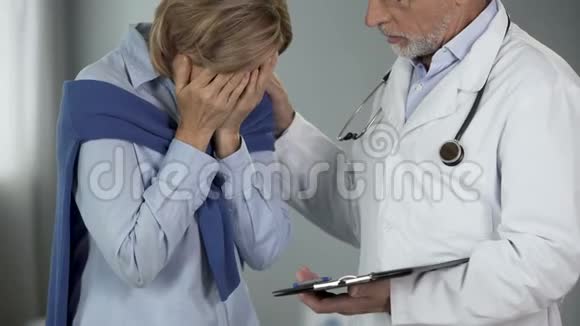 老年医生安慰哭泣的女性令人不安的消息疾病的晚期视频的预览图