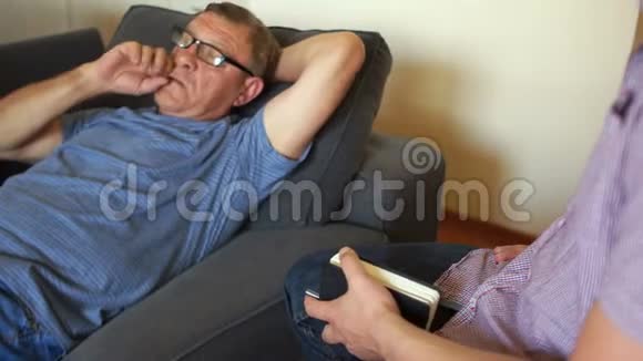 一个在心理医生接待的人医生向病人提问一个男人躺在沙发上一个心理学家视频的预览图
