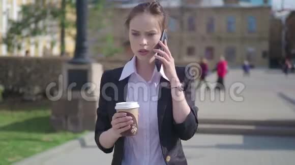 一位严肃的女经理戴着时髦的眼镜在纽约街头行走时在手机上交谈自信的女商人视频的预览图