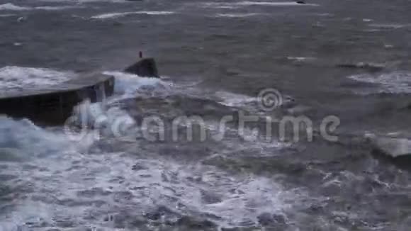在一个秋天的暴风雨午后汹涌的海浪拍打着苏格兰的海港墙视频的预览图