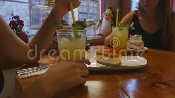 在咖啡馆喝柠檬水和吃蛋糕的年轻女性视频的预览图