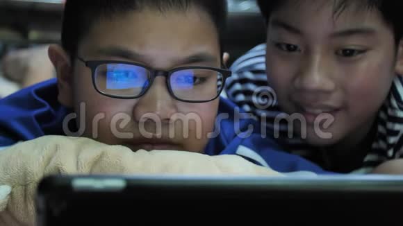 慢动作4K快乐的亚洲预科生微笑着看着平板电脑视频的预览图